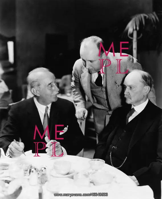 : Three men sitting together at a table : Three men sitting together at a table