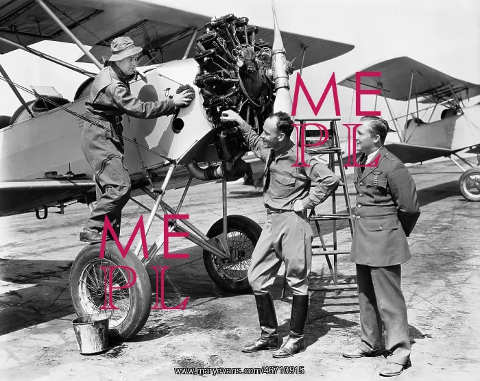 : Three men standing next to an aircraft having a : Three men standing next to an aircraft having a
