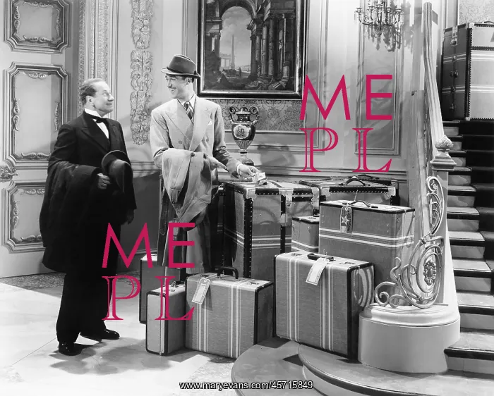 : Two men standing in the hallway with many suitcases : Two men standing in the hallway with many suitcases