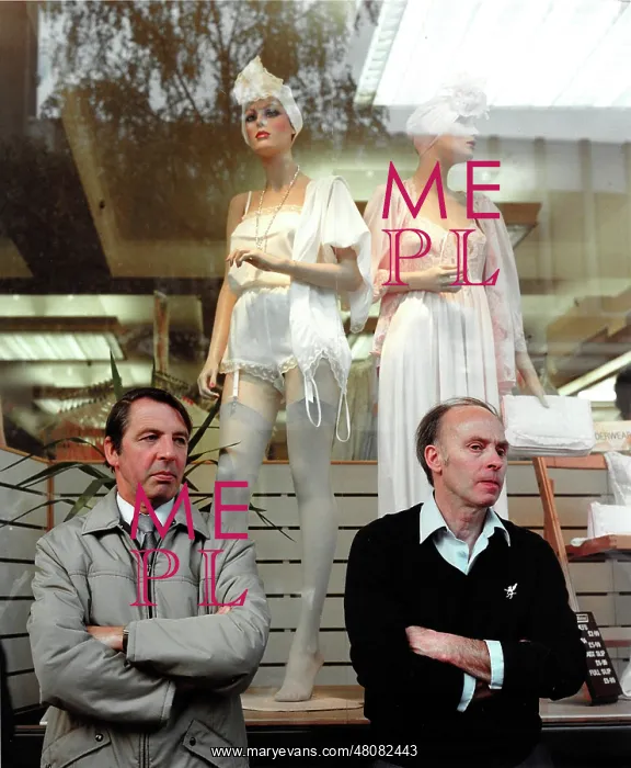 : Two men standing in front of window display : Two men standing in front of window display