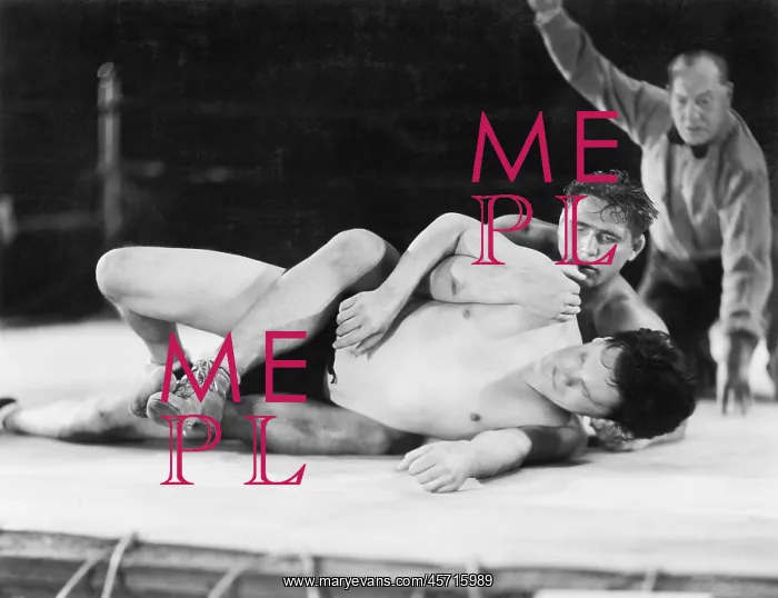 : Two men wrestling with a referee in the background : Two men wrestling with a referee in the background