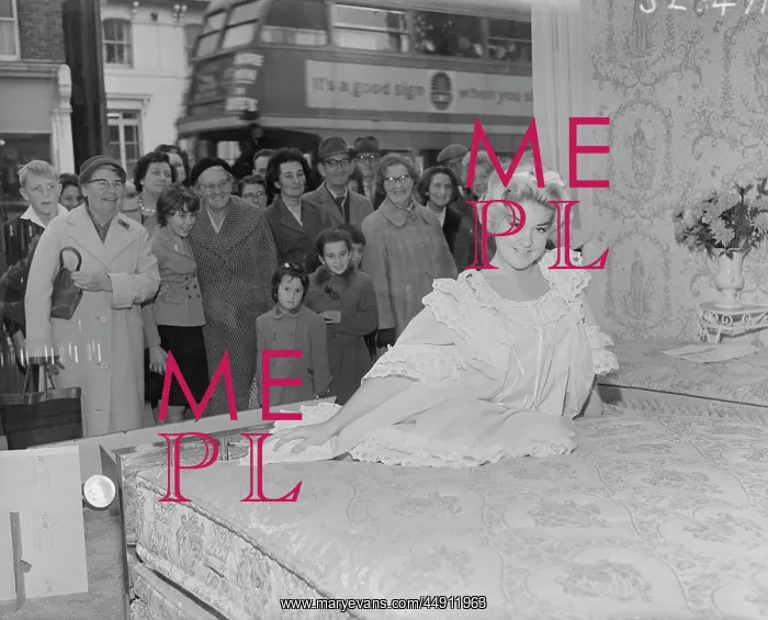 : Model poses on bed in shop window, Bexley : Model poses on bed in shop window, Bexley
