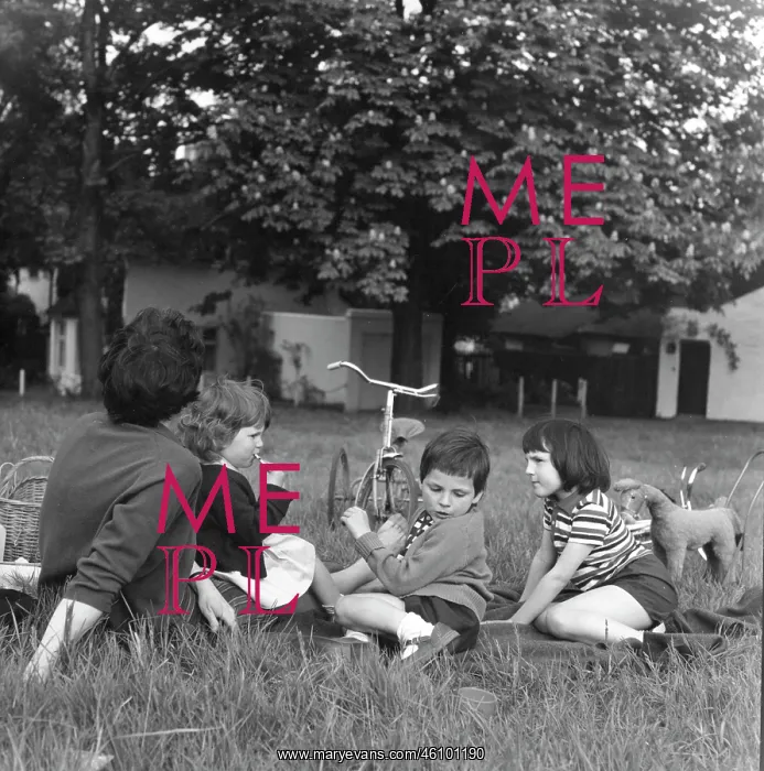 : Mother and three children sitting on the grass : Mother and three children sitting on the grass