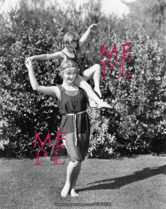 : Mother and daughter doing acrobatics in the back yard : Mother and daughter doing acrobatics in the back yard