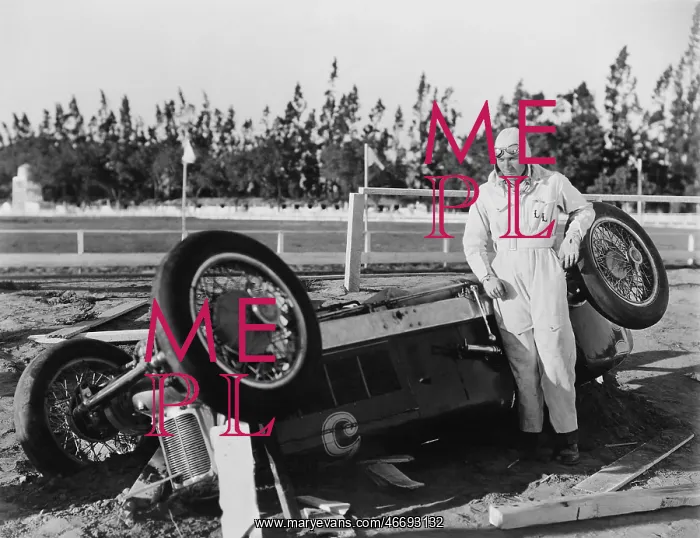 : Motor racing accident - driver with overturned car : Motor racing accident - driver with overturned car