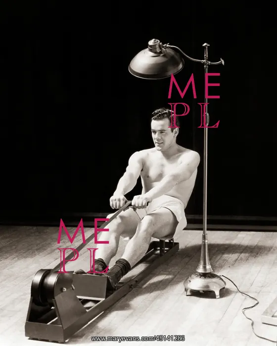 : Muscular Bare Chested Man Exercising on a Rowing : Muscular Bare Chested Man Exercising on a Rowing