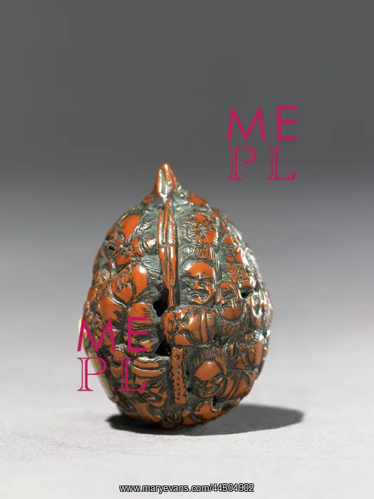: Netsuke formed from a walnut shell, carved with masks : Netsuke formed from a walnut shell, carved with masks