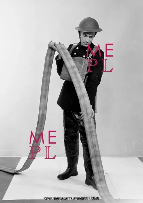 : NFS firefighter under-running a fire hose, WW2 : NFS firefighter under-running a fire hose, WW2