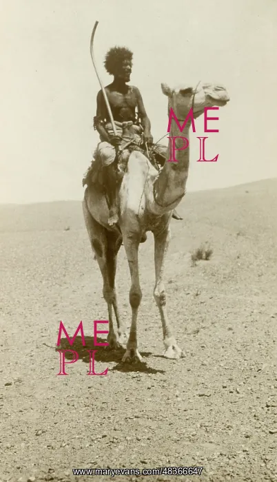  : A nomad riding a camel in the desert