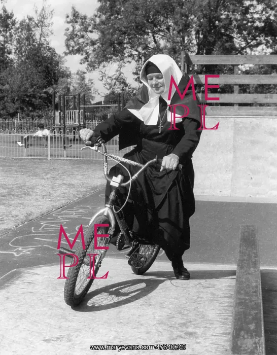  : Nun on a bicycle in a playground