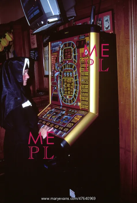 : Nun playing on a fruit machine : Nun playing on a fruit machine
