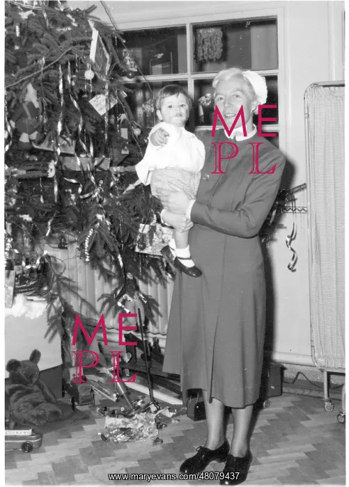 : Nurse holding child next to Christmas tree : Nurse holding child next to Christmas tree