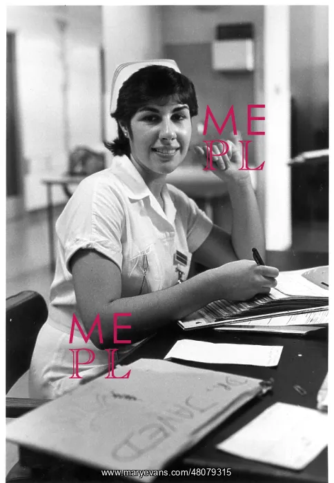 : Nurse seated at desk : Nurse seated at desk