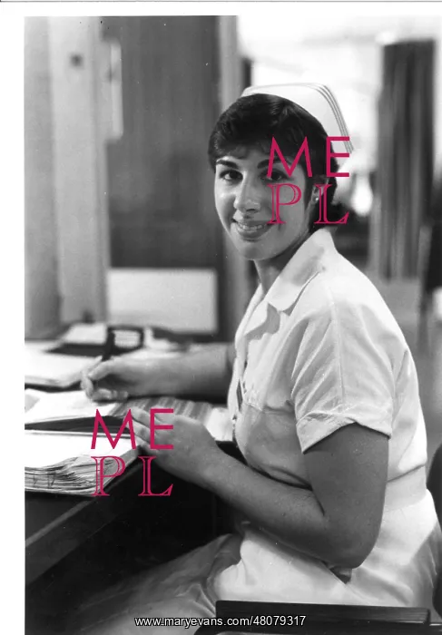 : Nurse seated at desk : Nurse seated at desk