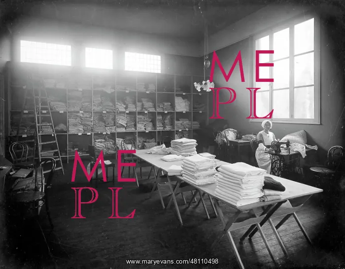 : Nurse at sewing machine in linen room : Nurse at sewing machine in linen room