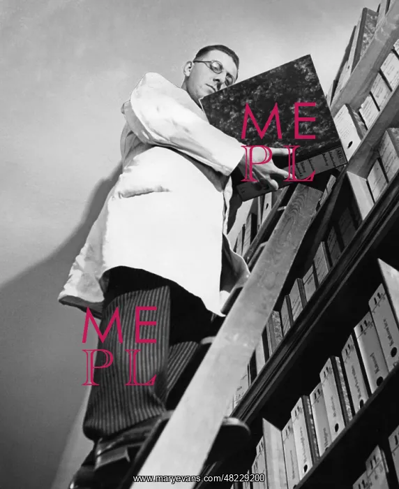 : Office worker organizing filing shelves, 1935 : Office worker organizing filing shelves, 1935