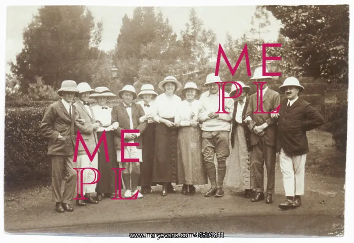 : Eleven people in a garden wearing pith helmets : Eleven people in a garden wearing pith helmets