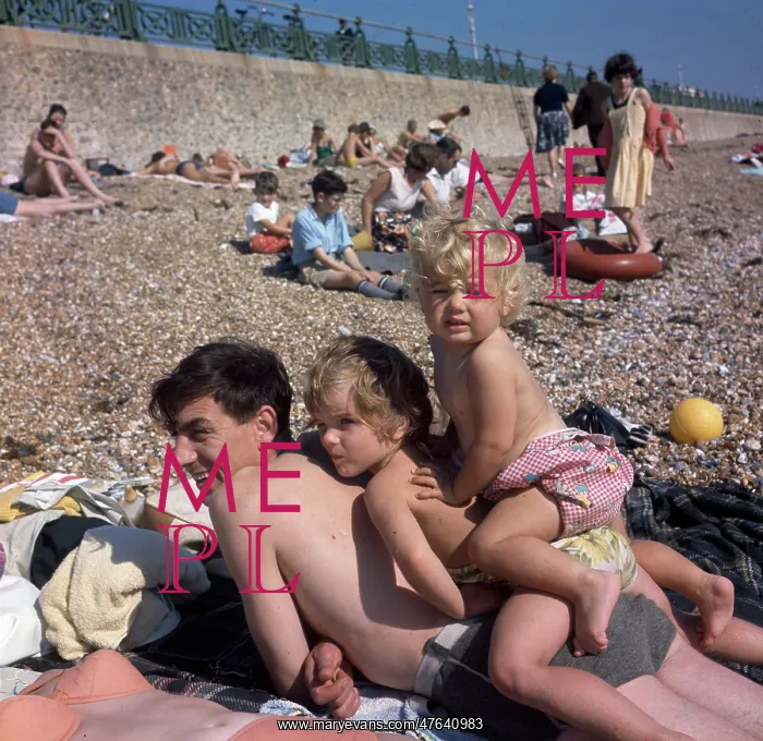  : People on holiday on a pebbly beach