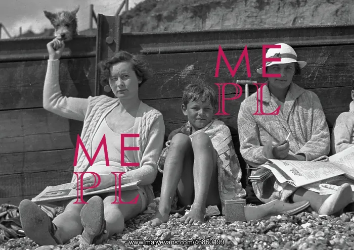 : People leaning against a breaker on a beach : People leaning against a breaker on a beach