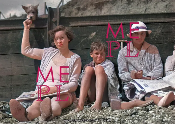 : People leaning against a breaker on a beach : People leaning against a breaker on a beach