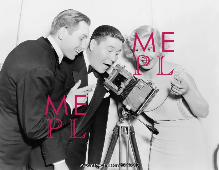 : Three people looking through a camera and laughing : Three people looking through a camera and laughing