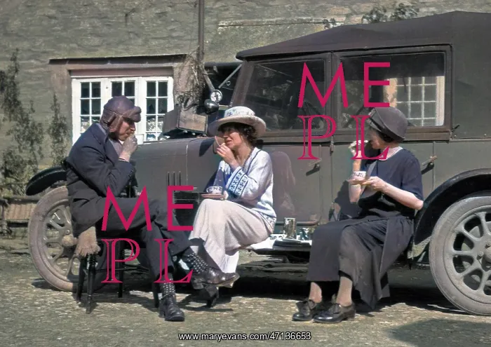 : Three people picnicking at the side of a car : Three people picnicking at the side of a car