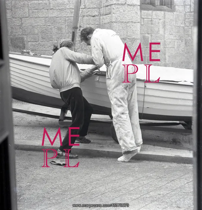 : Two people preparing a sailing dinghy : Two people preparing a sailing dinghy