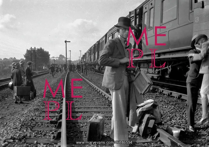: People on a railway track alongside a train : People on a railway track alongside a train