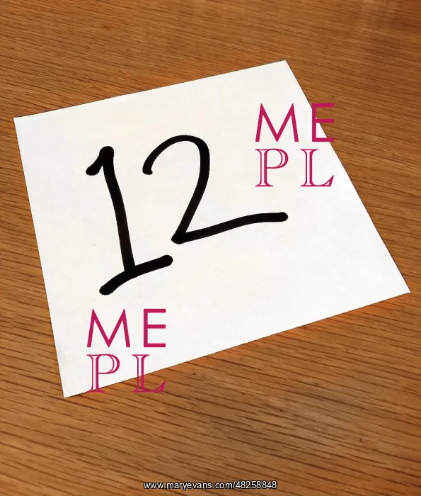 : Piece of paper on a desk with a large number 12 : Piece of paper on a desk with a large number 12