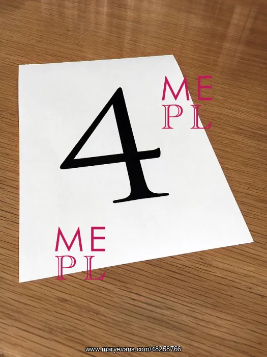 : Piece of paper on a desk with a large number 4 : Piece of paper on a desk with a large number 4