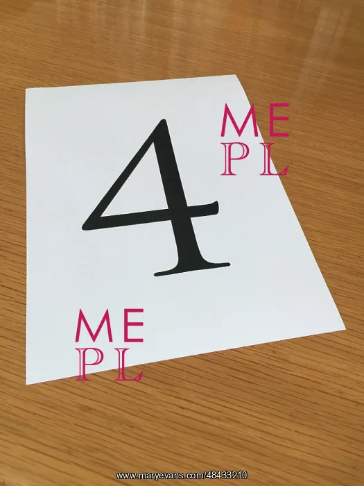 : Piece of paper on a desk with a large number 4 : Piece of paper on a desk with a large number 4
