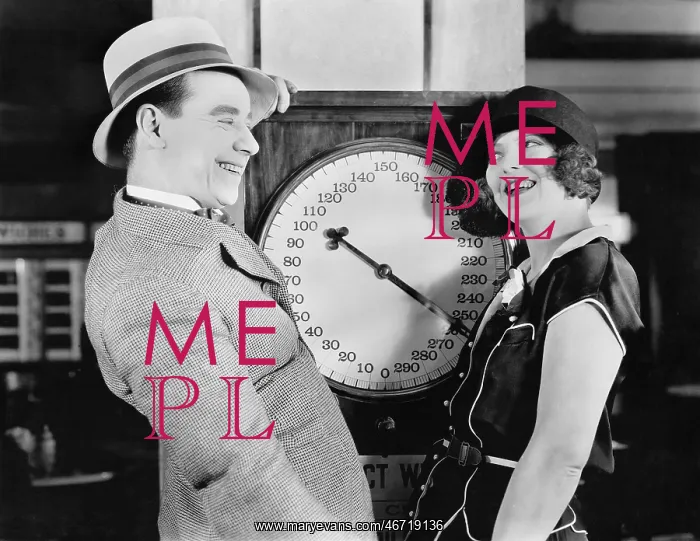 : Playful couple standing on scale : Playful couple standing on scale