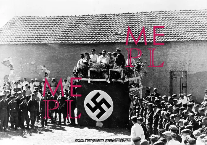 : Before a podium decorated with a swastika flag an : Before a podium decorated with a swastika flag an