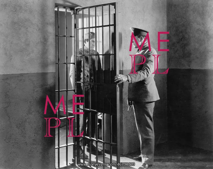 : Policeman and prisoner in a jail cell : Policeman and prisoner in a jail cell