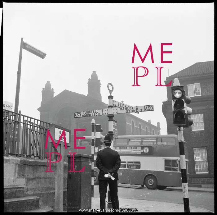 : A policeman standing beside a signpost at the : A policeman standing beside a signpost at the