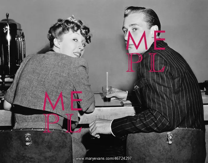 : Portrait of a couple sitting on a counter and looking : Portrait of a couple sitting on a counter and looking