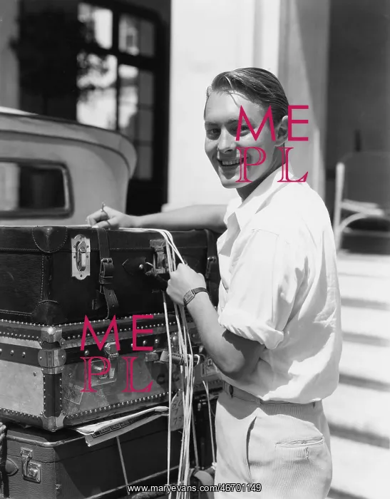 : Portrait of man tying down luggage : Portrait of man tying down luggage