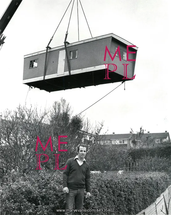: Prefabricated unit delivered to a garden by crane : Prefabricated unit delivered to a garden by crane