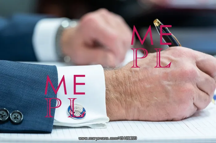 : President Joe Biden's hands as he takes notes : President Joe Biden's hands as he takes notes