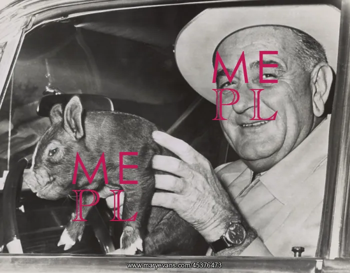 : President Lyndon Johnson holds a squirming : President Lyndon Johnson holds a squirming