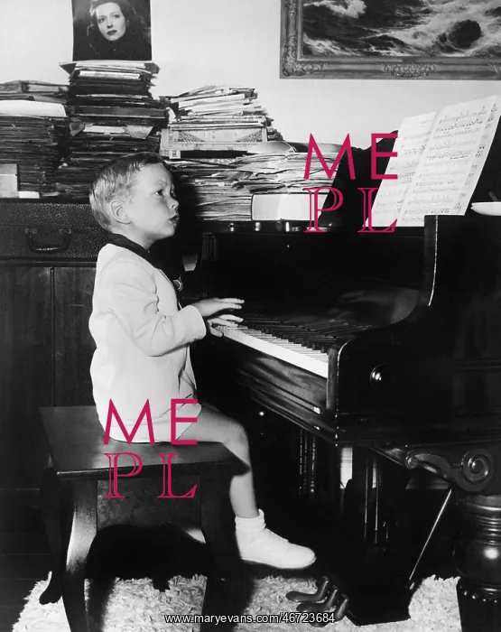 : Profile of a boy sitting on a stool and playing a piano : Profile of a boy sitting on a stool and playing a piano