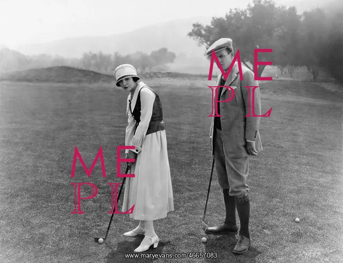 : Profile of a couple playing golf in a golf course : Profile of a couple playing golf in a golf course