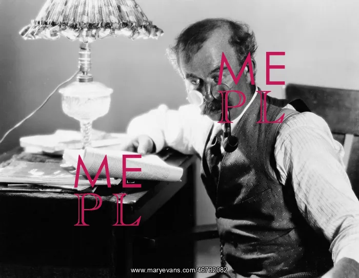 : Profile of a man sitting at a desk and holding a : Profile of a man sitting at a desk and holding a
