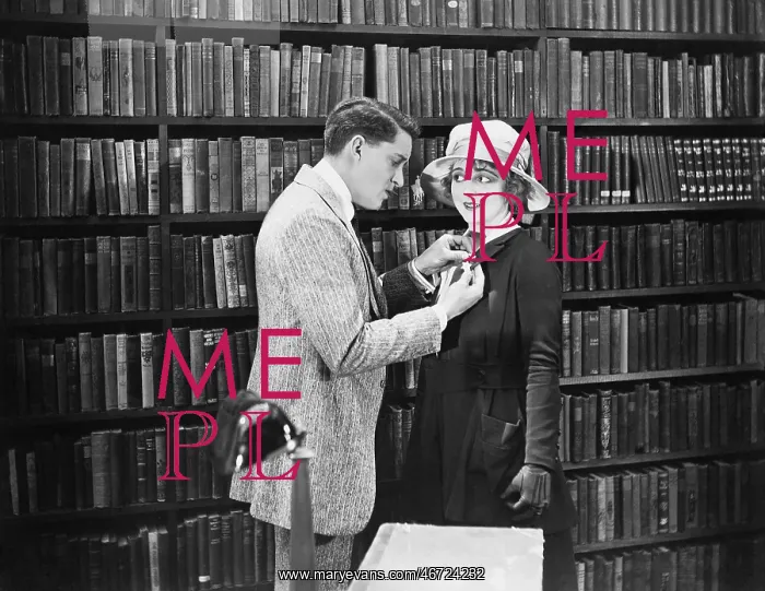 : Profile of a young man attaching a brooch on a young : Profile of a young man attaching a brooch on a young