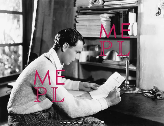 : Profile of a young man reading a paper at his desk : Profile of a young man reading a paper at his desk