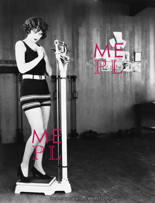 : Profile of a young woman measuring her weight on : Profile of a young woman measuring her weight on