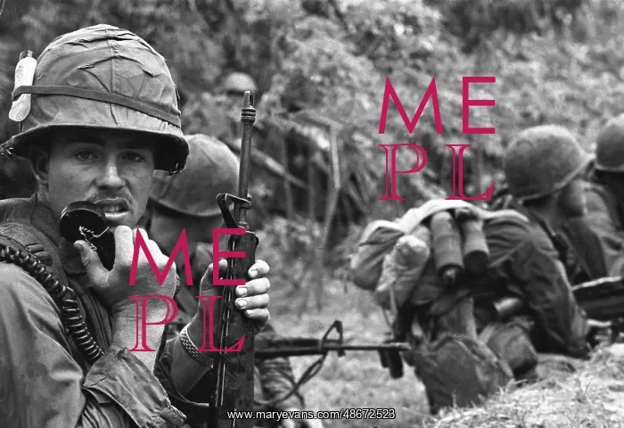 : A radio operator armed with an M-16 rifle talks : A radio operator armed with an M-16 rifle talks
