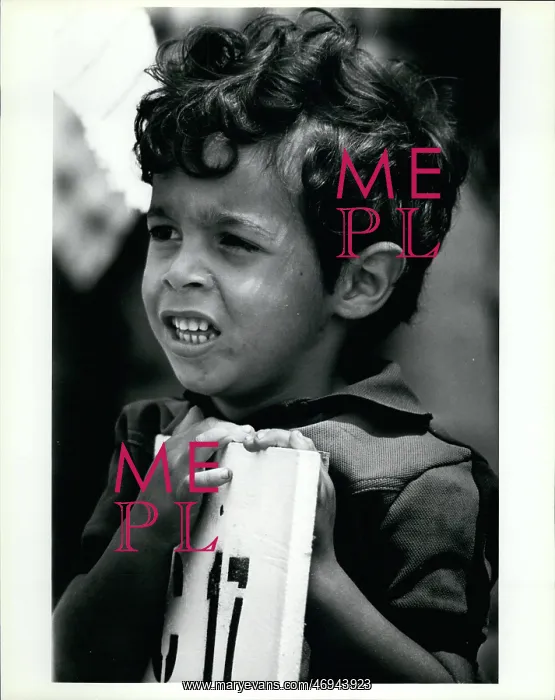 : Refugees. Feb. 25 A young Cuban refugee leans against the sign that shows : Refugees. Feb. 25 A young Cuban refugee leans against the sign that shows