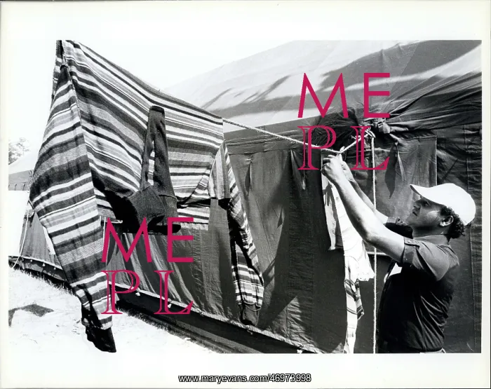 : Refugees. A Cuban refugee hangs up cloths to dry in the tent at Fort Walton : Refugees. A Cuban refugee hangs up cloths to dry in the tent at Fort Walton