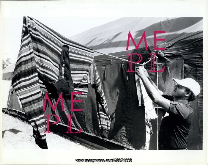 : Refugees. A Cuban refugee hangs up cloths to dry in the tent city at Fort : Refugees. A Cuban refugee hangs up cloths to dry in the tent city at Fort